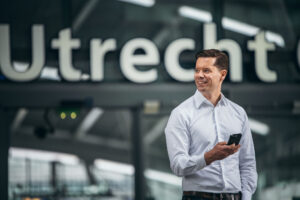 Man met zijn mobiel voor station Utrecht Centraal