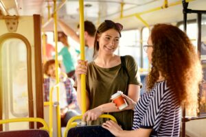 Twee jonge vrouwen praten met elkaar in de bus