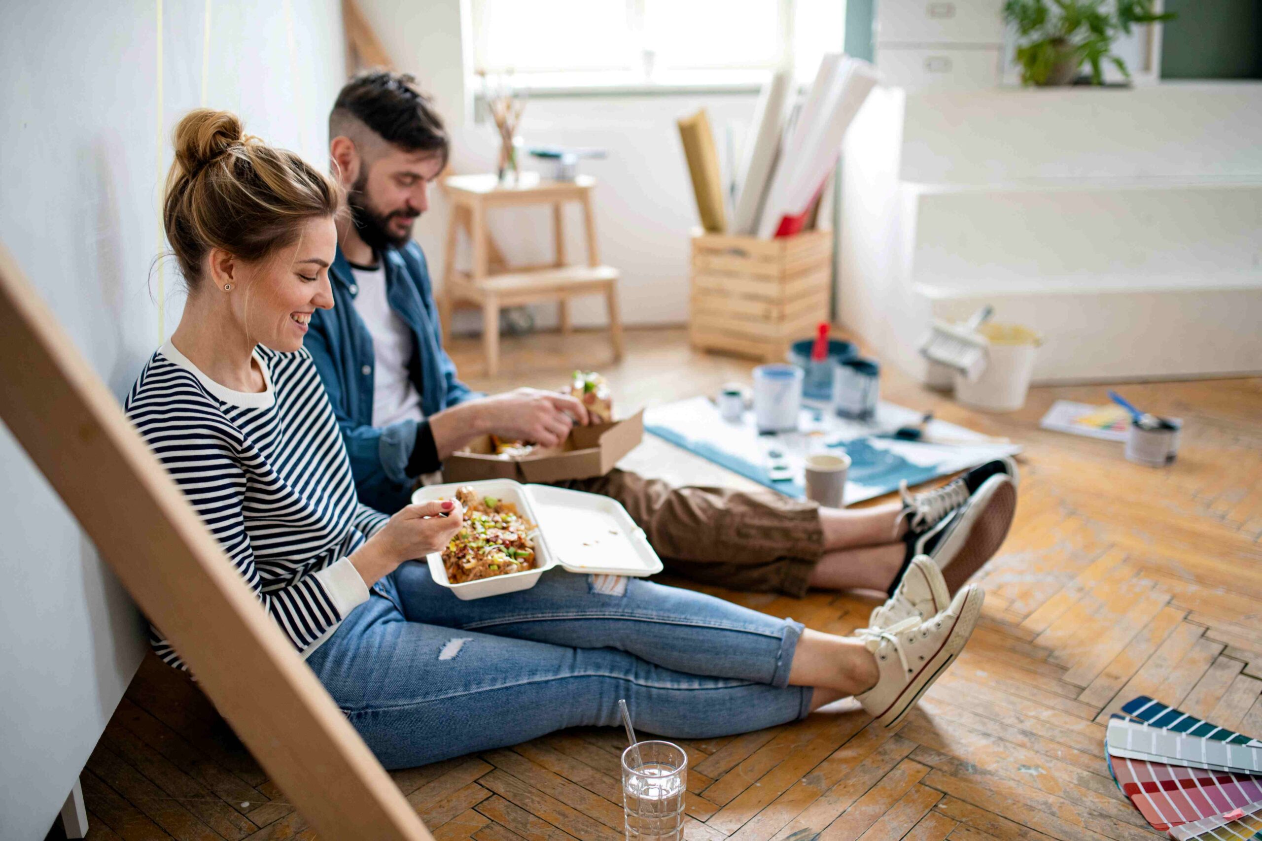 Koppel zit op de vloer relaxt te lunchen
